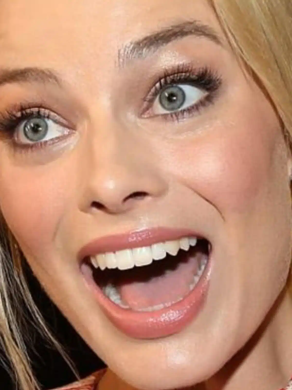 “Margot Robbie showing perfect incisor length during soft smile.”