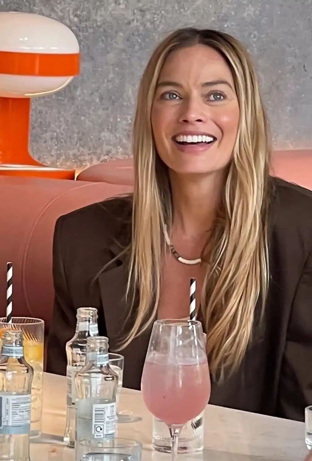 “Margot Robbie with delicate upper tooth display and aligned smile arc.”