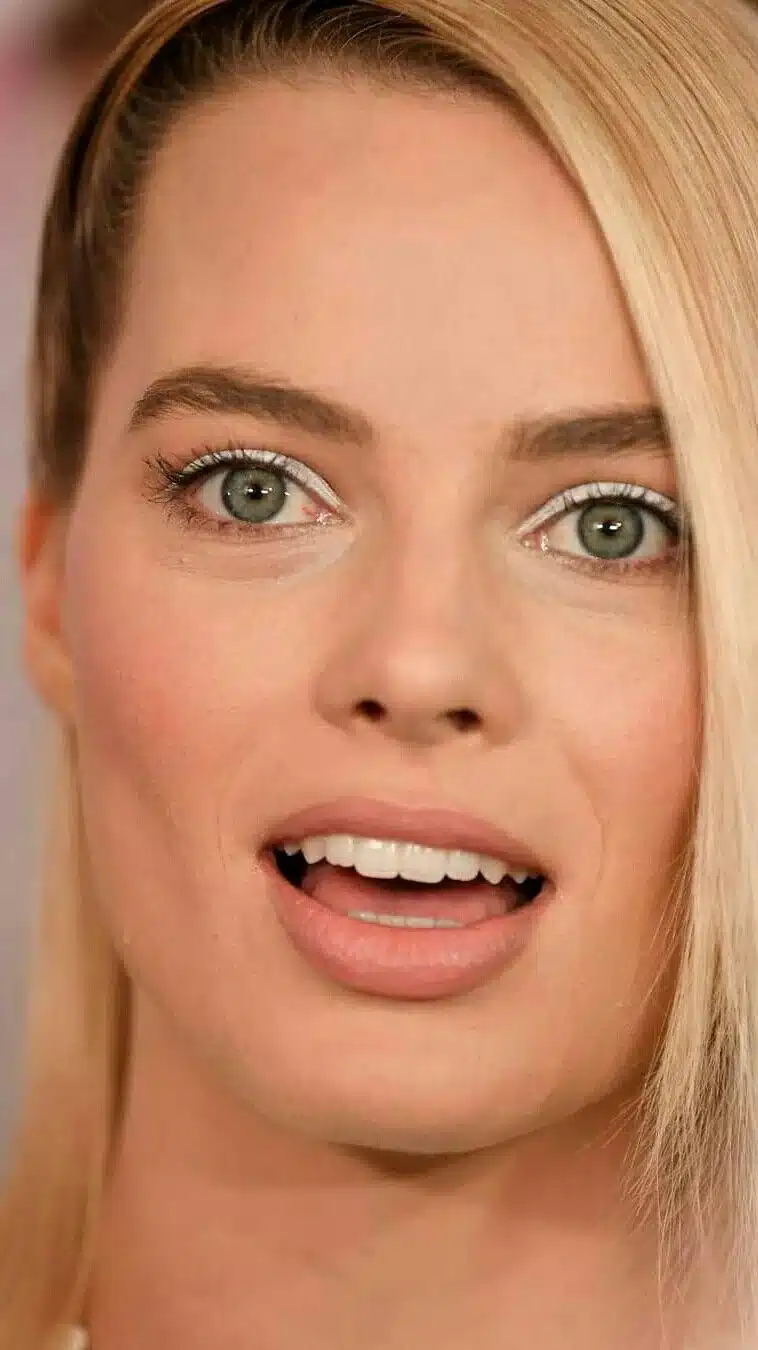 “Margot Robbie’s iconic bright smile captured in soft studio lighting.”