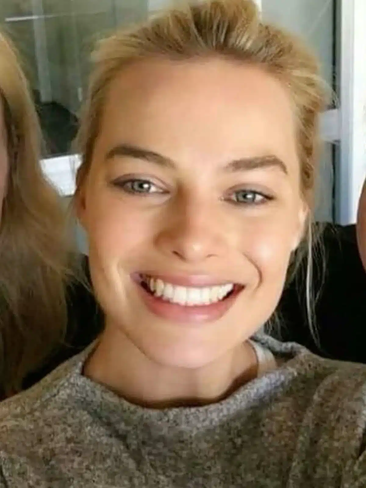 “Margot Robbie’s enamel texture visible in close-up smile shot.”