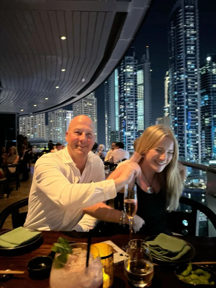 Couple dining on a rooftop terrace overlooking the city at night
