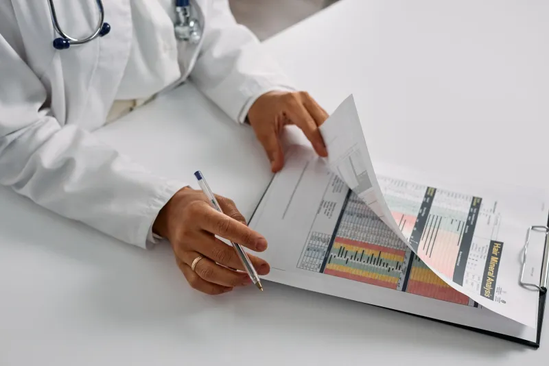 A clinician reviewing a patient's case file and notes before a treatment plan is proposed