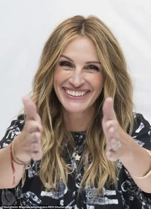 “Julia Roberts photographed mid-laughter with vibrant expressive smile.”